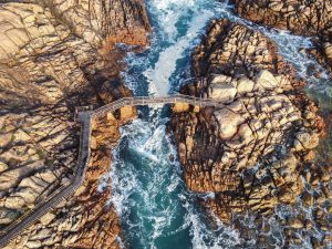 Rough sea pushing under the bridge against rocks at Canal Rocks, Yallingup, WA