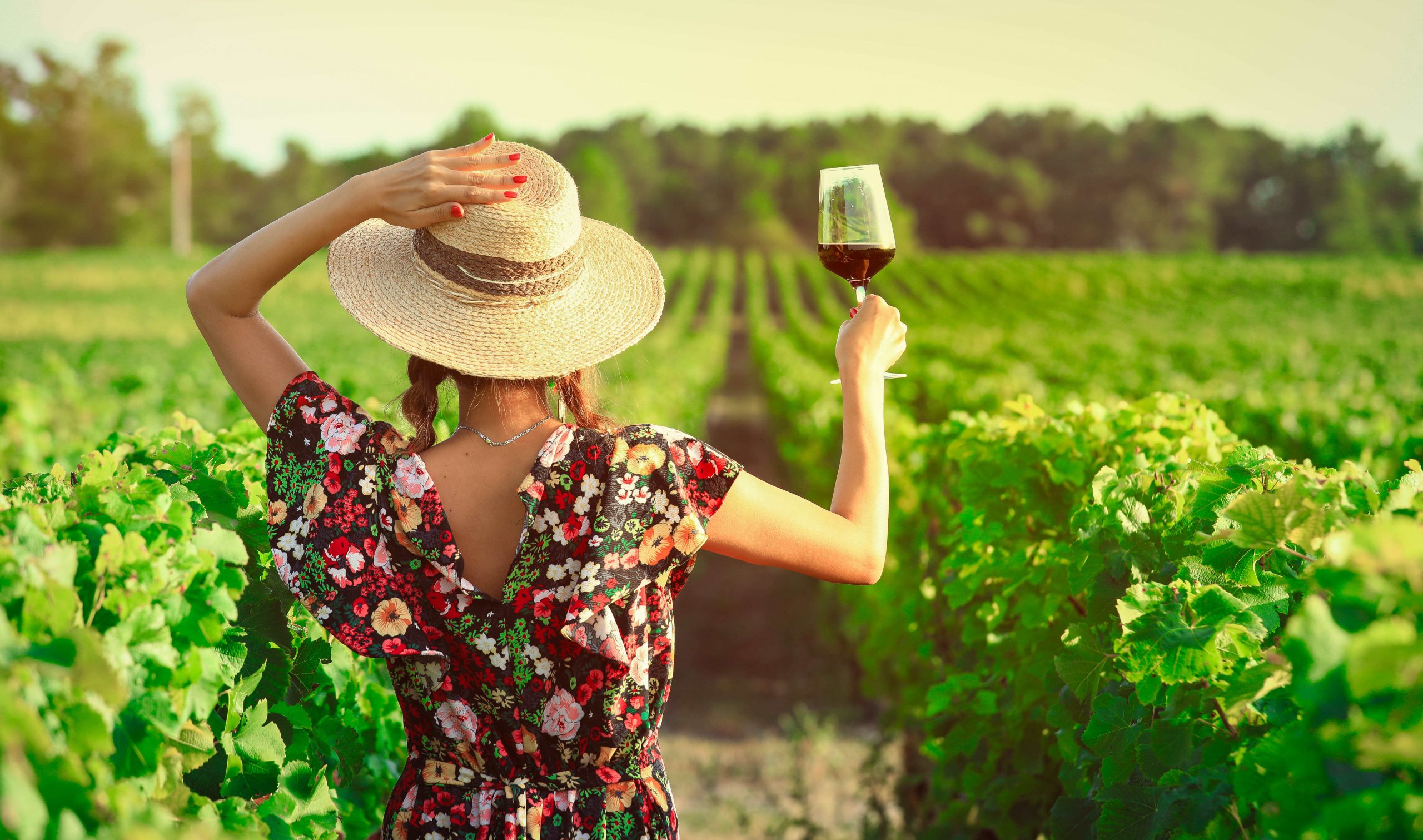 a girl enjoying a glass of red wine at a vineyard